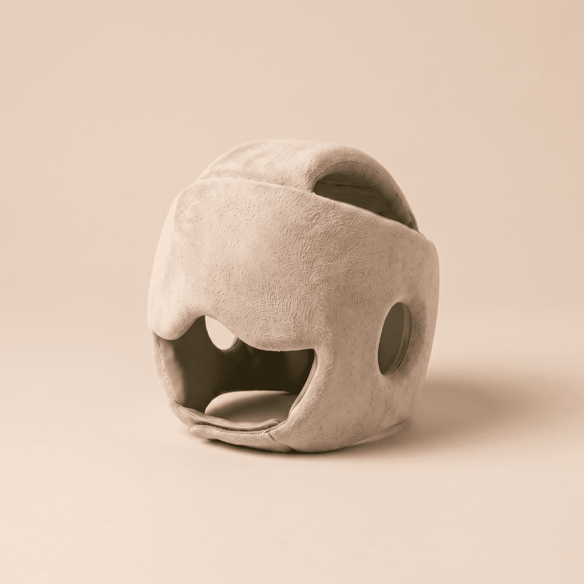 The Soothe Helmet — a soft, oat-toned cooling cap with a calm sage-green lining, resting on a warm studio surface.